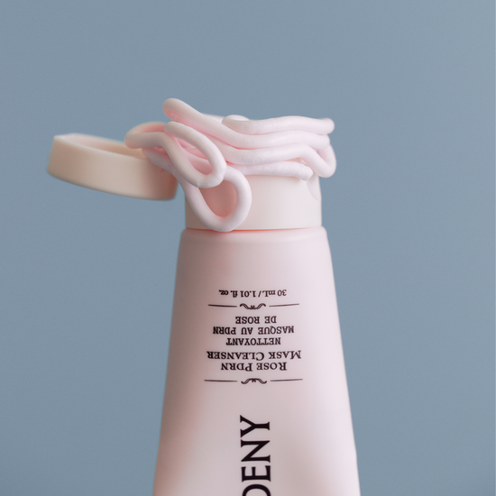 Gardeny Rose PDRN Mask Cleanser tube with the cap open and soft pink cream swirled around the edge, emphasizing its rich mask-like texture that transforms into a gentle foam. Formulated with plant-based Damask Rose PDRN, the cleanser refines texture, boosts hydration, and supports smoother, healthier-looking skin as part of a compact daily cleansing ritual.