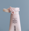 Gardeny Rose PDRN Mask Cleanser tube with the cap open and soft pink cream swirled around the edge, emphasizing its rich mask-like texture that transforms into a gentle foam. Formulated with plant-based Damask Rose PDRN, the cleanser refines texture, boosts hydration, and supports smoother, healthier-looking skin as part of a compact daily cleansing ritual.
