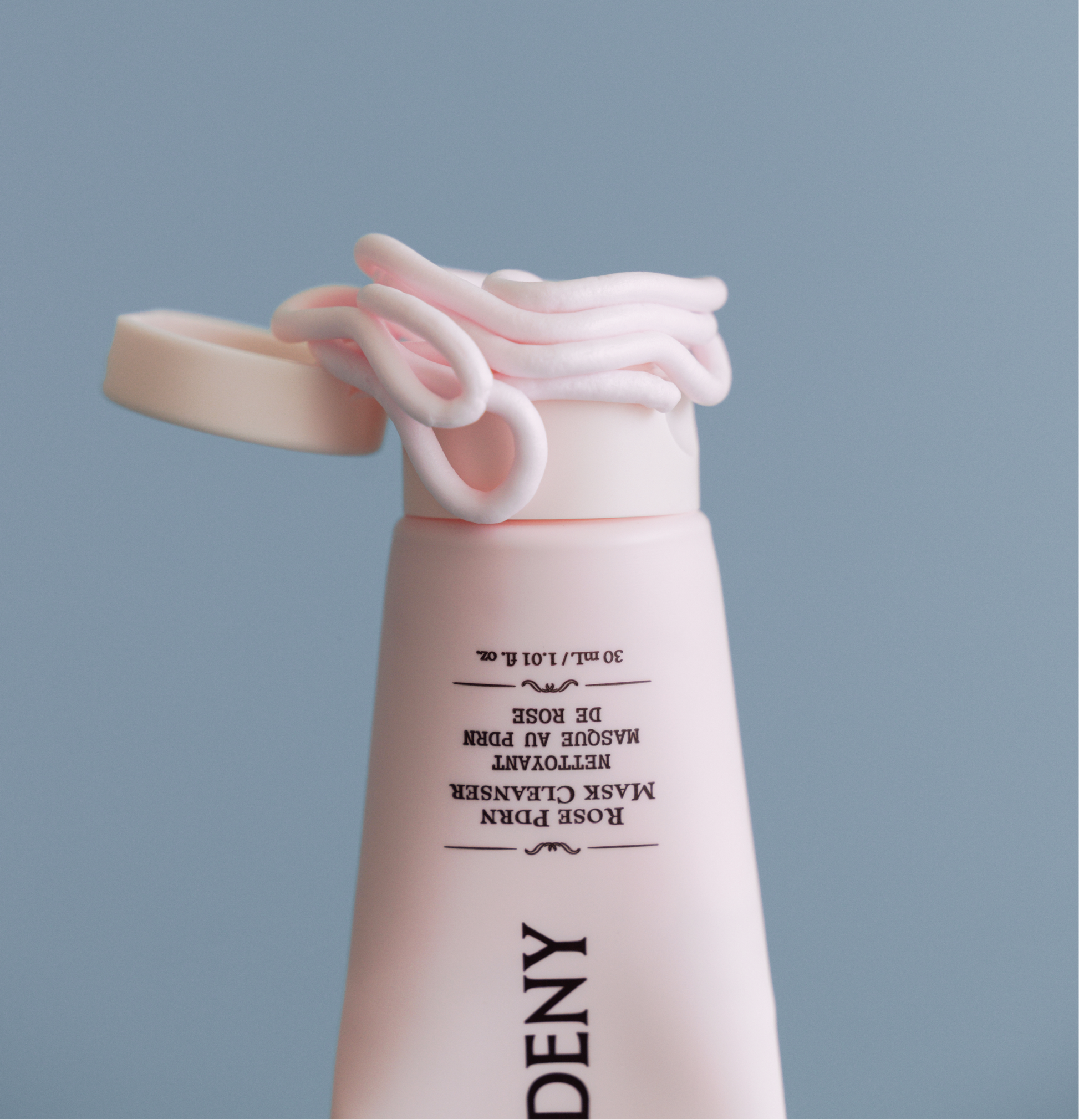 Gardeny Rose PDRN Mask Cleanser tube with the cap open and soft pink cream swirled around the edge, emphasizing its rich mask-like texture that transforms into a gentle foam. Formulated with plant-based Damask Rose PDRN, the cleanser refines texture, boosts hydration, and supports smoother, healthier-looking skin as part of a compact daily cleansing ritual.