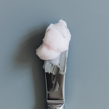 Close-up of a stainless steel spatula lifting a soft scoop of Gardeny’s Rose PDRN Cleansing Balm, showcasing its whipped, creamy texture. The image highlights the balm’s melting, hydrating formula designed to dissolve makeup, SPF, and buildup while supporting the moisture barrier and leaving skin refreshed, nourished, and comfortably clean.