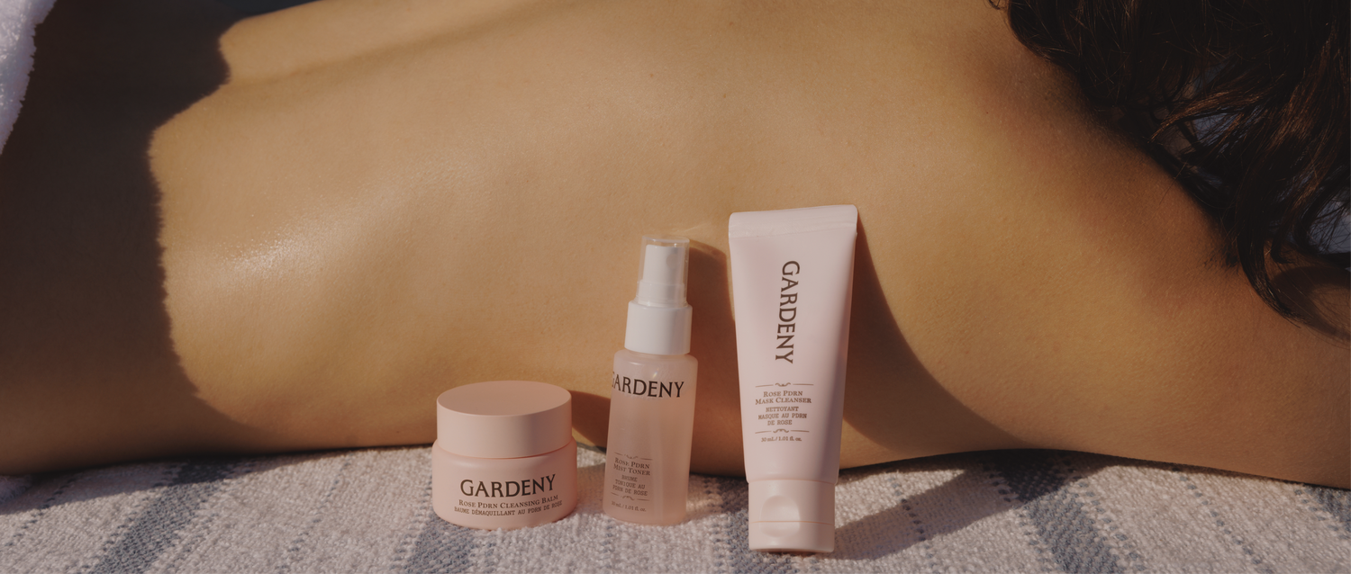 Gardeny Essential Mini Trio placed on a towel outdoors beside a sunlit back, paired with the words Reset, Refresh, Nourish, Anywhere. The imagery reflects the trio’s ability to cleanse, hydrate, and support skin radiance through Rose PDRN, offering a calming, travel-friendly routine that fits effortlessly into self-care moments at home or away.
