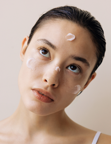 Model with dots of Gardeny’s Rose PDRN formulas applied across the face, including forehead, cheeks, and chin, showcasing the trio’s soft, skin-first textures. The visual reflects the calming, hydrating, moisture-retaining benefits of the Essential Mini Trio and how its gentle formulas support a smooth, radiant complexion during daily routines.