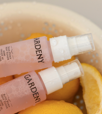 Close-up of two Gardeny Rose PDRN Mist Toner bottles covered in fresh water droplets and surrounded by sliced citrus, symbolizing refreshing, lightweight hydration. Highlights Gardeny’s Korean plant-based Damask Rose PDRN technology that boosts moisture retention, radiance, and a non-sticky glow, ideal for users seeking gentle toners that keep skin calm, hydrated, and naturally bright.